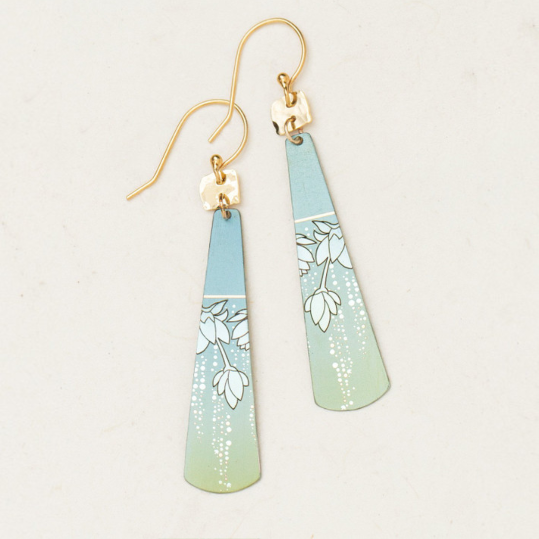 Introducing the Holly Yashi Tula Earrings, a stunning pair of tapered, elongated earrings with a captivating gradient design that transitions from light blue at the top to light green at the bottom. These earrings are adorned with a delicate white floral pattern, gold-plated hooks, and an iridescent Austrian sparkle for a truly romantic look.