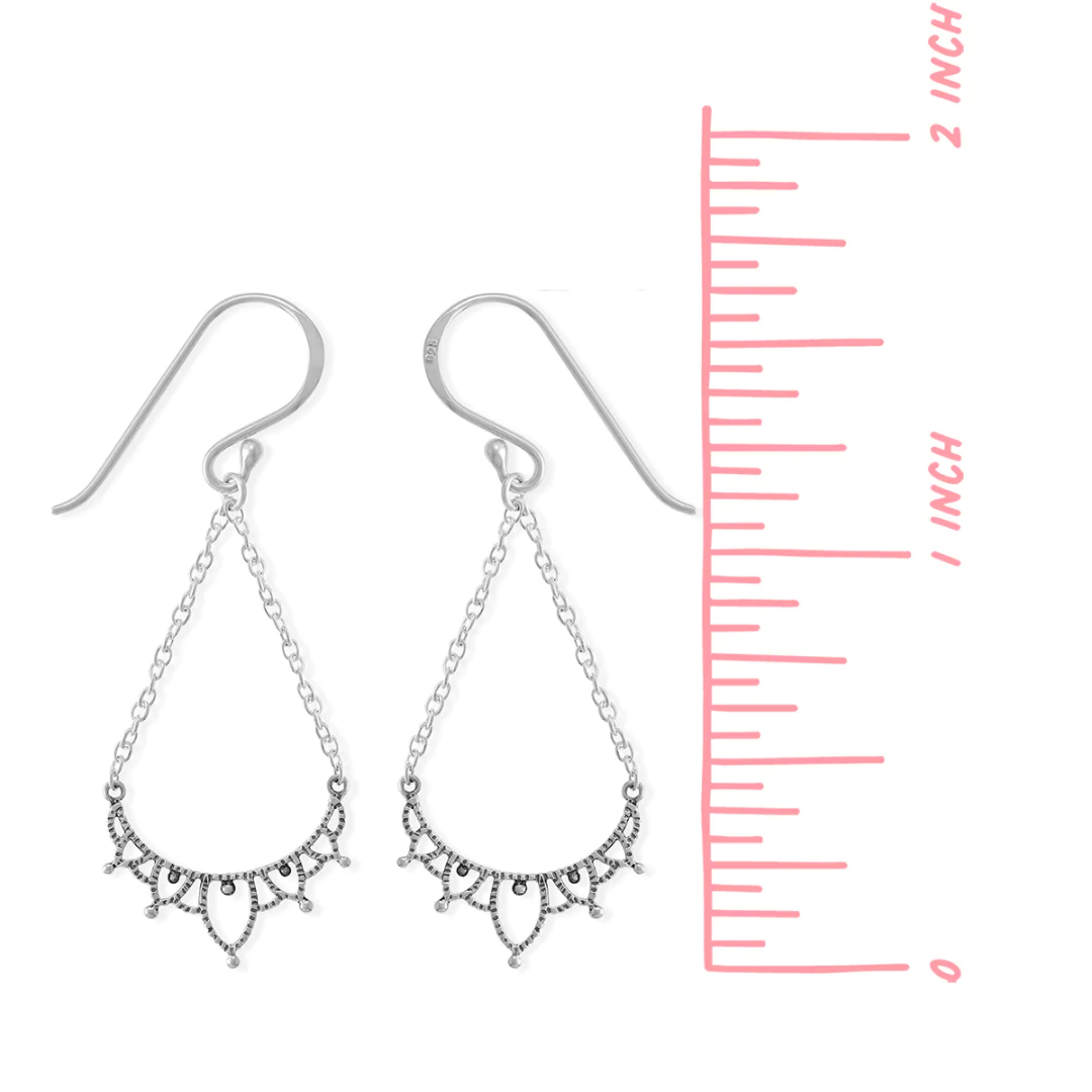 Silver filigree earring on white background. Dangles from an ear wire, on two chains, brought together by a filigreed piece of silver. Measures 1.5 inches long from top of ear wire to bottom of earring.