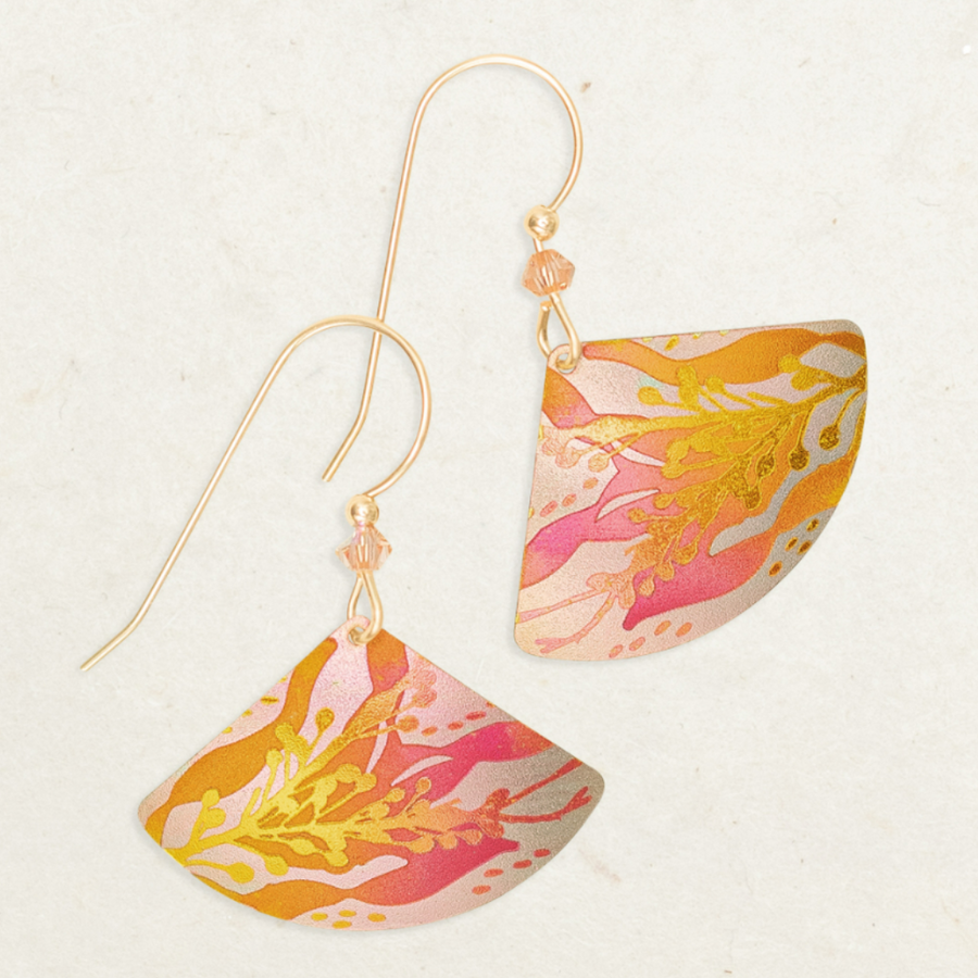 Holly Yashi Sea Meadow Earrings - Gold colored coral with pink/orange ombre seaweed behind on a light peach background - rounded oblong triangle shaped niobium on pink beaded gold overlaid earwires.