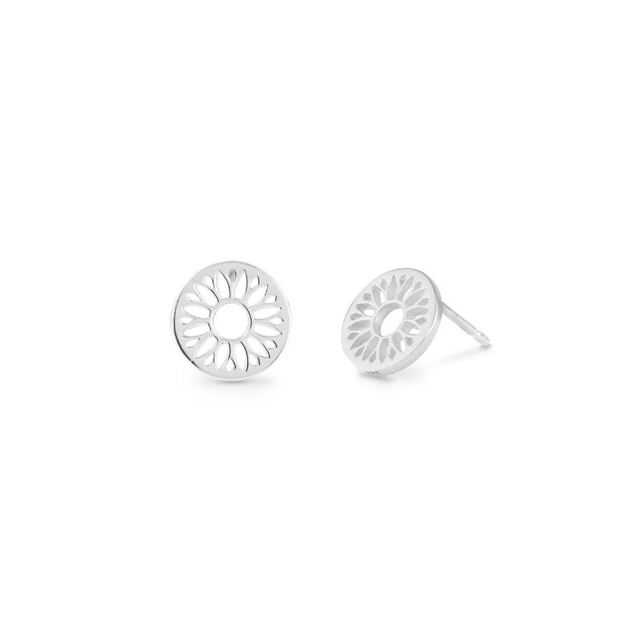 The Boma Sun Flower Studs feature a pair of silver stud earrings with a circular cut-out flower design, crafted from 925 Sterling Silver. These hypoallergenic earrings are displayed side by side on a white background, with one earring lying flat and the other standing upright, showcasing the intricate petal pattern.