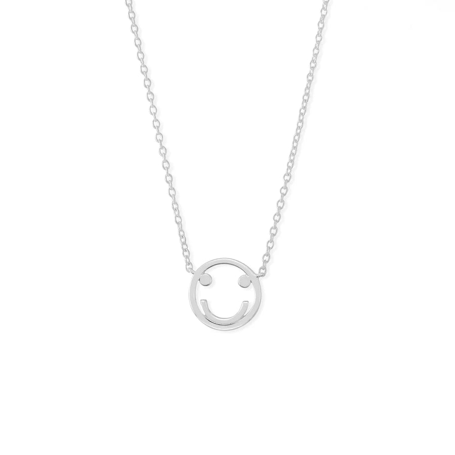 The Boma Happy Face Necklace is a delicate silver piece featuring a small smiley face pendant, crafted from 925 sterling silver. The circular pendant has cut-out eyes and a curved smile, centered on a fine chain. Hypoallergenic and perfect for everyday wear, it pairs beautifully with matching earrings against a white background.