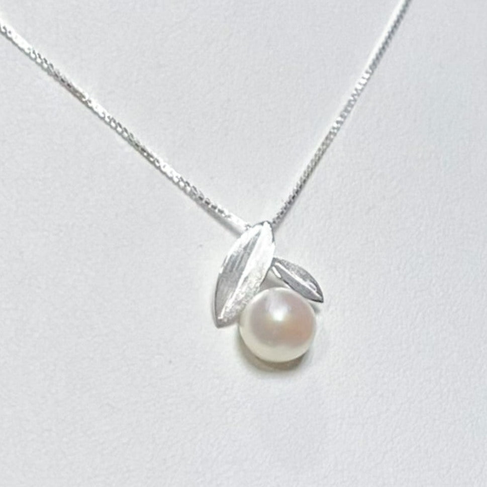 White freshwater pearl with two small silver leaves on top suspended on a 18" inch 925 Sterling Silver box chain