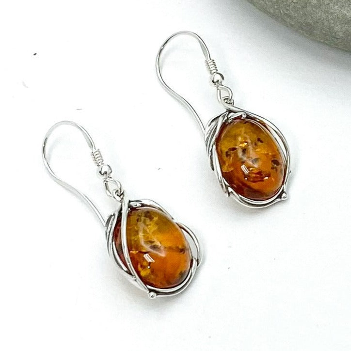 Urban Sterling Silver - Oval shaped Baltic Amber in floral / vine-like 925 sterling silver setting - on fish-hook earwire