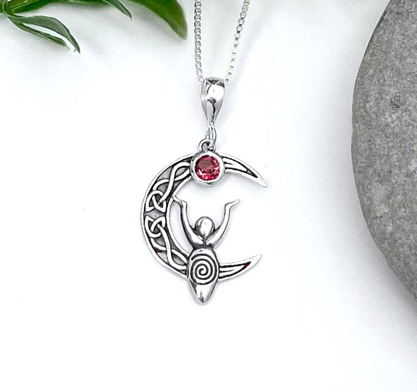 Celtic knot Crescent Moon adorned with a small circle garnet ontop, sitting along the middle is a spiral moon goddess, hands up towards the stone. 925 Sterling Silver setting and chain. 