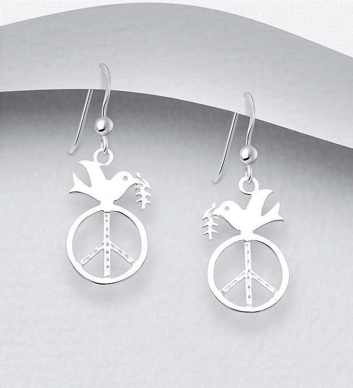 Sterling silver dangle earrings of the side profile of a dove sitting atop a peace sign. The wings of the dove are stretched out back, and it had a leaf in its beak