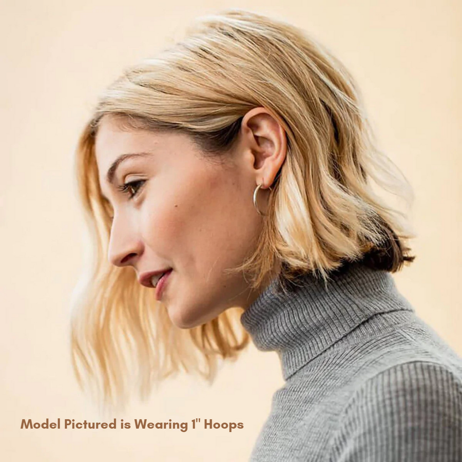 1" snap top silver hoop on blonde woman's ear from side view. Woman is wearing grey turtleneck. Text on picture reads "Model Pictured is Wearing 1" Hoops"