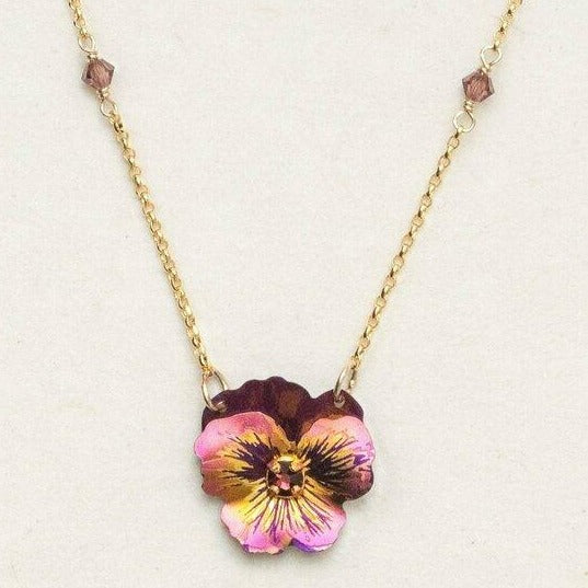 Niobium hand-crafted purple pansy flower pendant attached to a gold-filled chain. Chain has a single purple swarovski crystal linked into the metal about one and a half inches from the pendant.