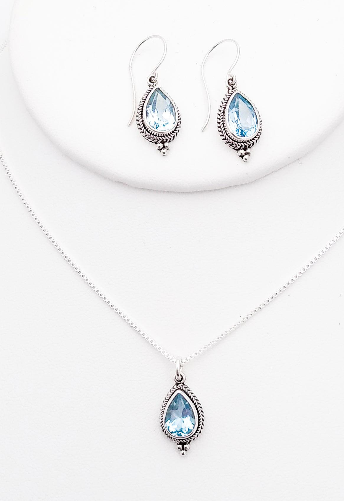 Sterling silver teardrop-shaped drop earrings on a French wire with ornate setting around a Blue Topaz stone in the middle. December birth stone. Matching pendant available.