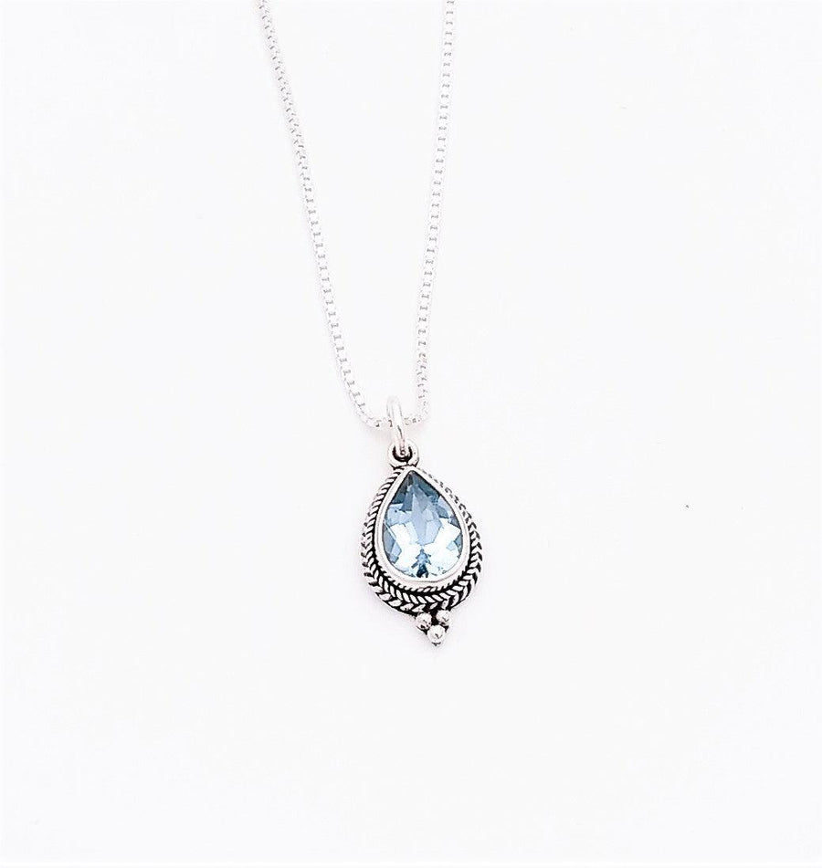 Sterling silver teardrop-shaped pendant with a blue topaz stone in the middle. Surrounding it is a bali rope design with three metal balls at the bottom. Comes on an 18-inch chain, December birthstone