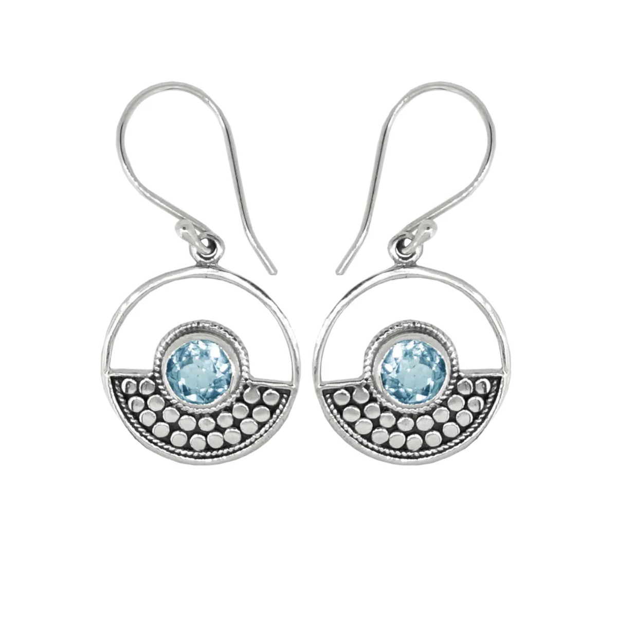 Sterling Silver design in a circle surrounds a circular blue topaz stone on ear wires. Half of the circle is dotted with an oxidized sterling design, the other half is open.  On a plain white background. 