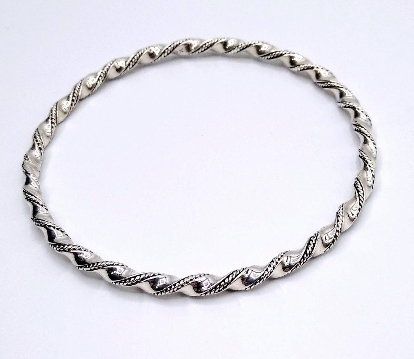 Sterling Silver Wire Twist Bangle - the silver is in a large twist pattern with a small braid pattern running between the twists