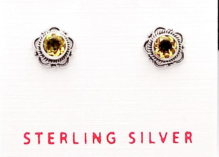 Sterling silver bali-design studs shaped in a floral pattern with a citrine in the middle. Citrine is the birthstone for November