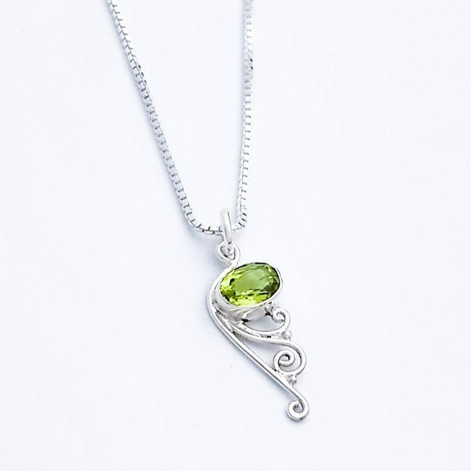 Sterling silver pendant with peridot and filigree at the bottom.