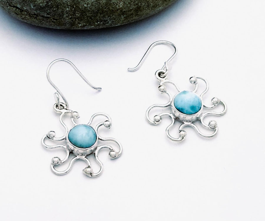 Sterling sun drop earrings with a circular larimar stone in the center. Each has 6 curved rays with a ball on the end of each.