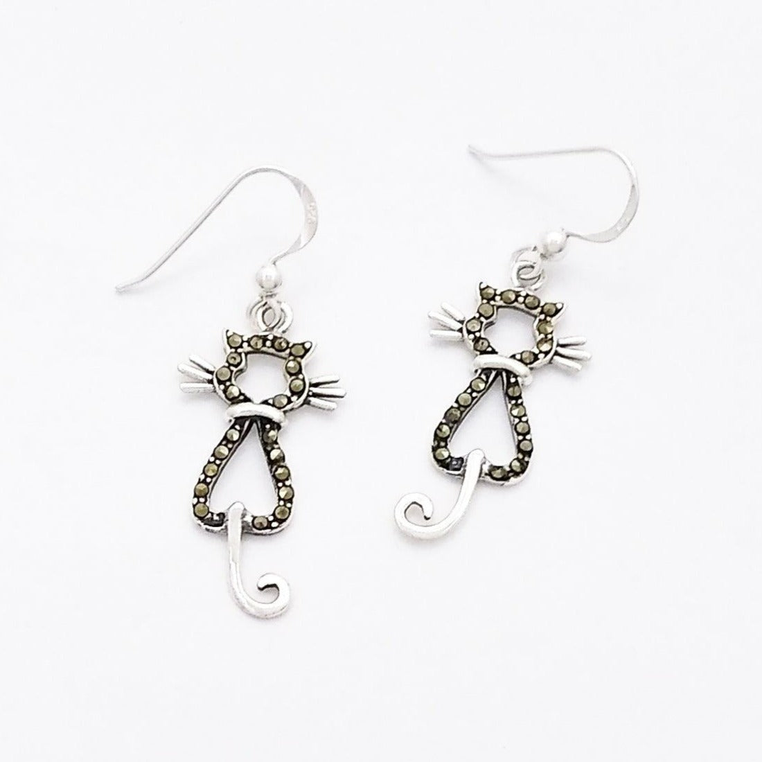 Silver dangle earrings of the silhouette of a cat from the back. The body is outlined in marcasites while the tail, whiskers, and collar are plain silver.