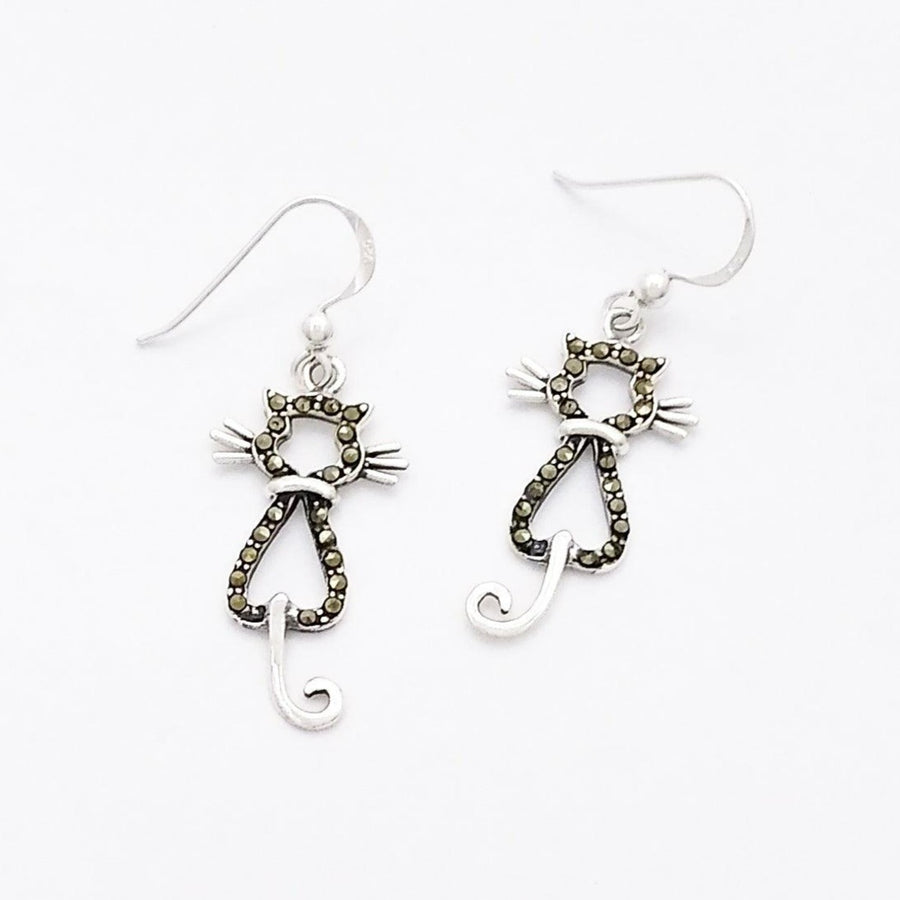 Silver dangle earrings of the silhouette of a cat from the back. The body is outlined in marcasites while the tail, whiskers, and collar are plain silver.