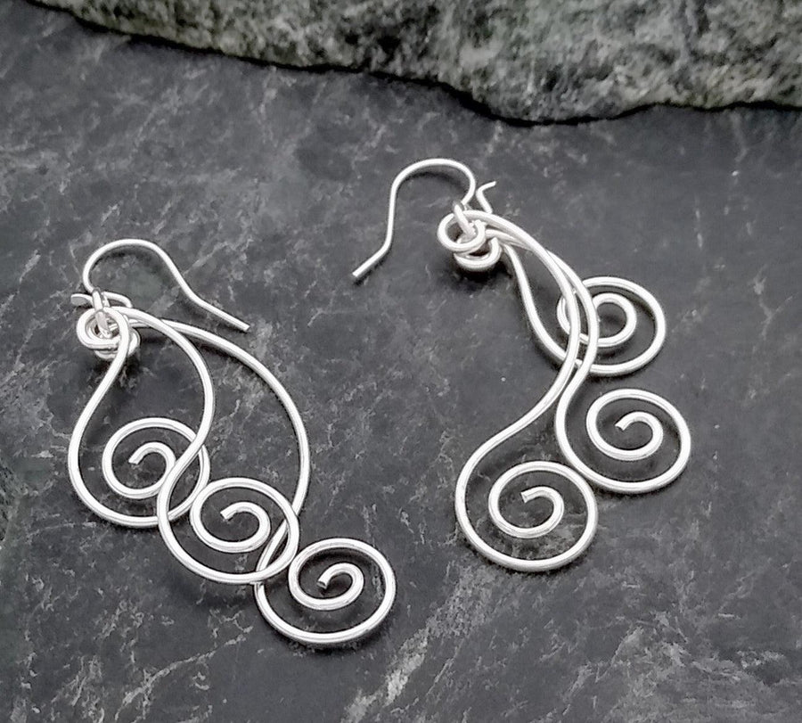 Sterling silver wire dangles with three separate swirl designs on a French wire.