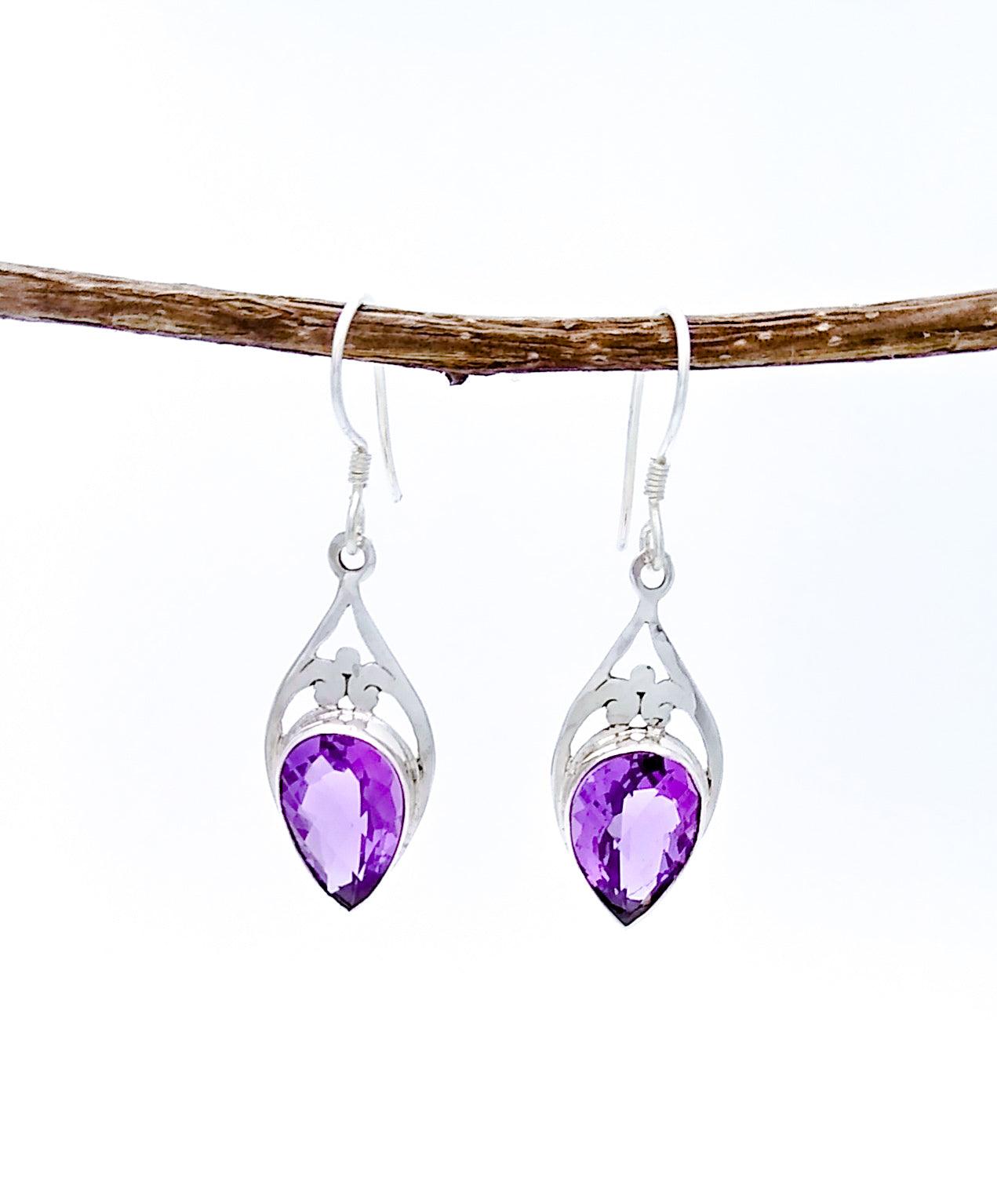 drop earring with Upside-down taeardrop shaped faceted amethyst stone set in sterling in a complementary shape to form a full diamond. The silver has decorative cutouts
