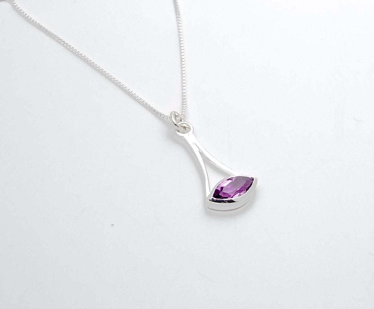Sterling silver geometric pendant with an amethyst stone at the bottom with a cut-out in the middle. 18-inch chain