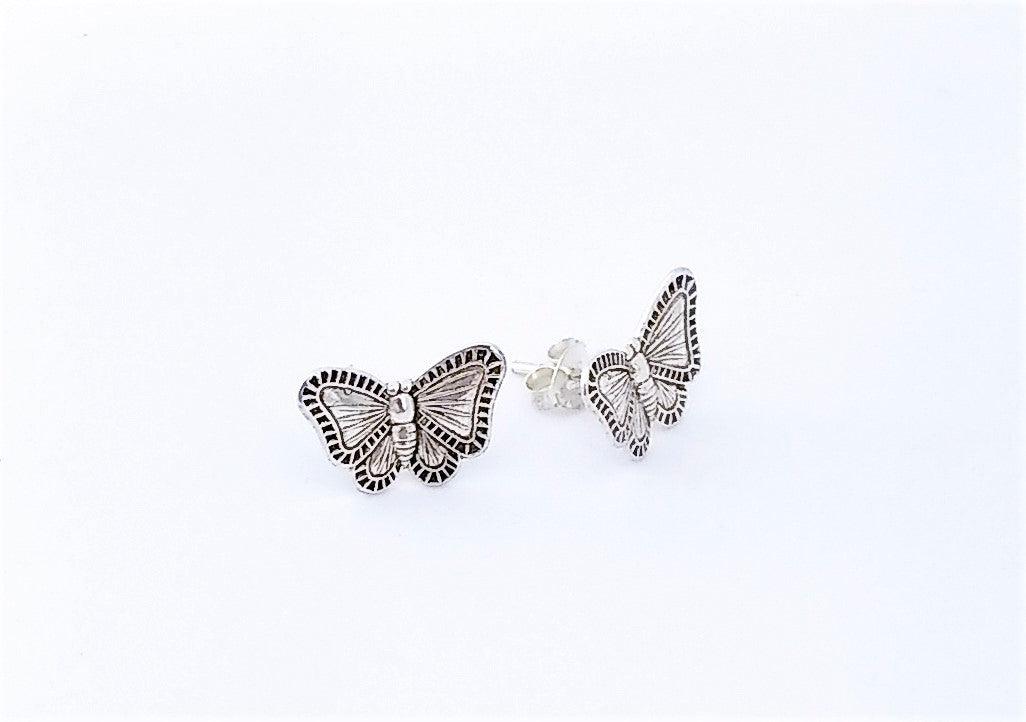 Sterling silver butterfly stud earrings with it's wings expanded. Wings have a checkered design along the borders with lines stretching from the inside of the wings to the outer edge.