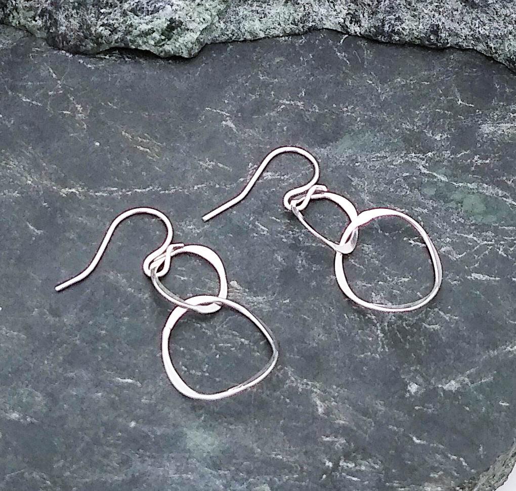 Sterling silver twisty intertwined hoops. The bottom hoop is slightly bigger than the top. Dangles from a French wire