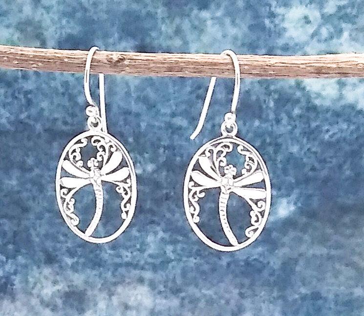 Sterling silver ovular drop earrings on a French wire. Contains a simple dragonfly design in the middle with floral designs along the top and sides