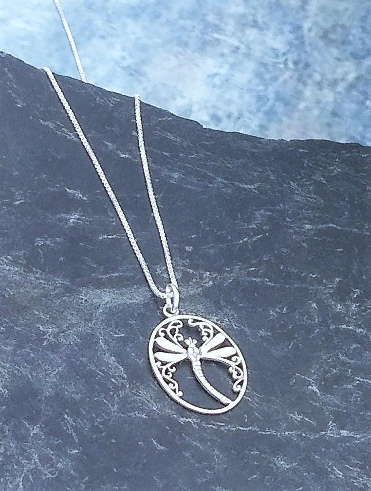 Sterling silver ovular pendant with a smooth dragonfly centered in the middle, with small swirl designs at the top and sides. Comes on an 18-inch chain