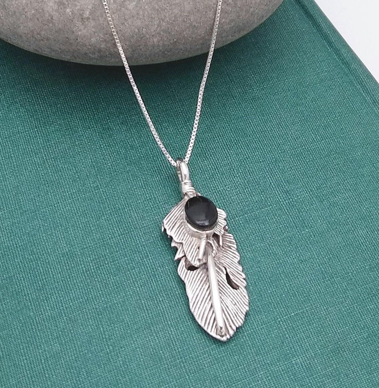 Sterling silver feather design with venations etched into the metal, and a small Onyx stone at the top. Comes on an 18-inch sterling chain