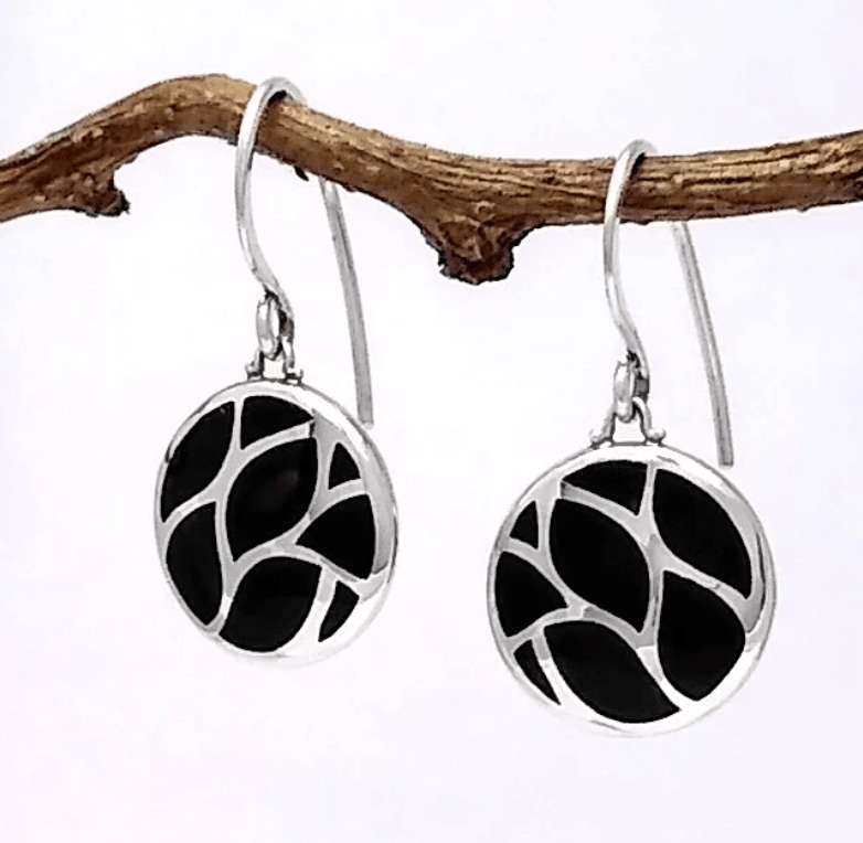 Boma circular silver earring with 8 pieces of black onyx inlaid. Earrings are on a French wire.