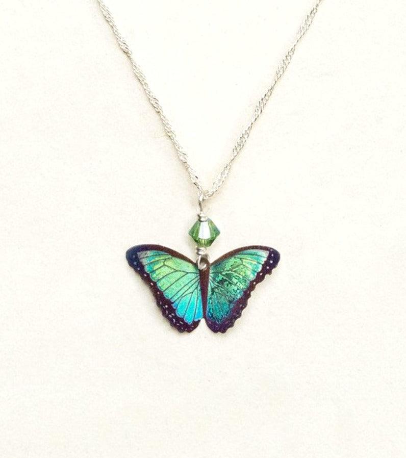 A bright green butterfly pendant with green bead on a silver chain