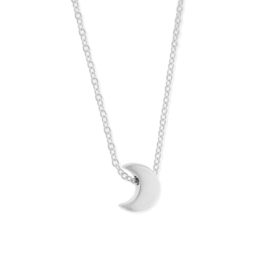 Small silver moon pendant on delicate silver chain, seen on white background.