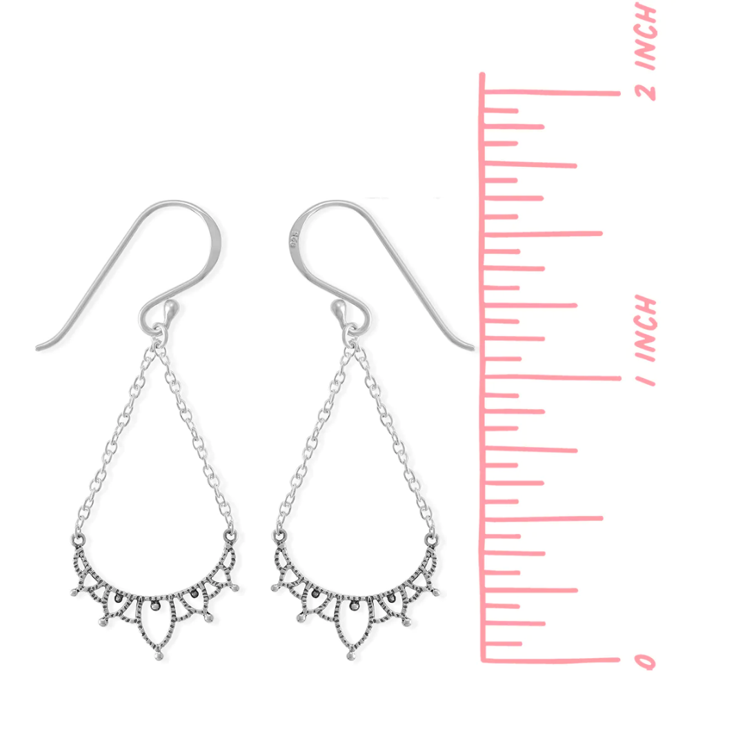 Silver filigree earring on white background. Dangles from an ear wire, on two chains, brought together by a filigreed piece of silver. Measures 1.5 inches long from top of ear wire to bottom of earring. 