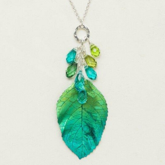 Green and blue gradient elm leaf necklace made of Niobium. 7 beads dangle from a sterling silver hammered hoop, from which hangs an 18-inch sterling silver chain.