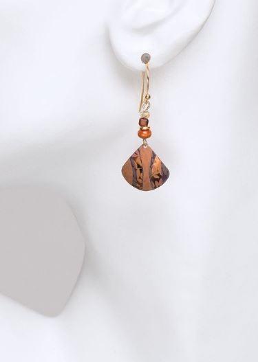 View of the orange earrings dangling from the ear.