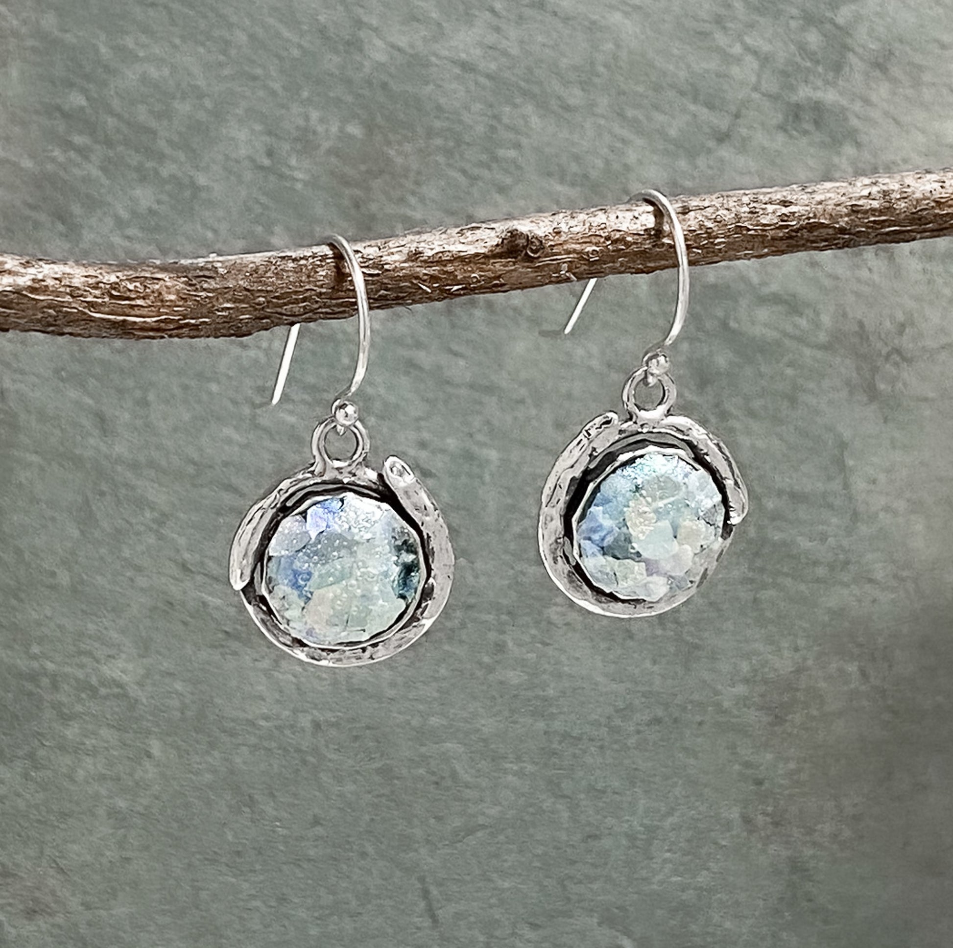 Sterling silver drop earrings with a Roman glass circle as the centerpiece. The glass is 2000 years old. 1.25" long including the wire. 
