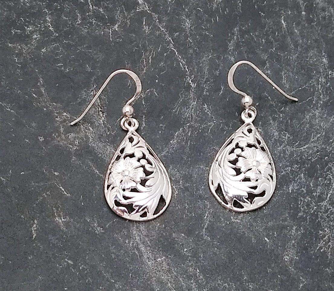 Sterling silver teardrop-shaped earrings on a French wire with a floral cutout in the middle with leaves.
