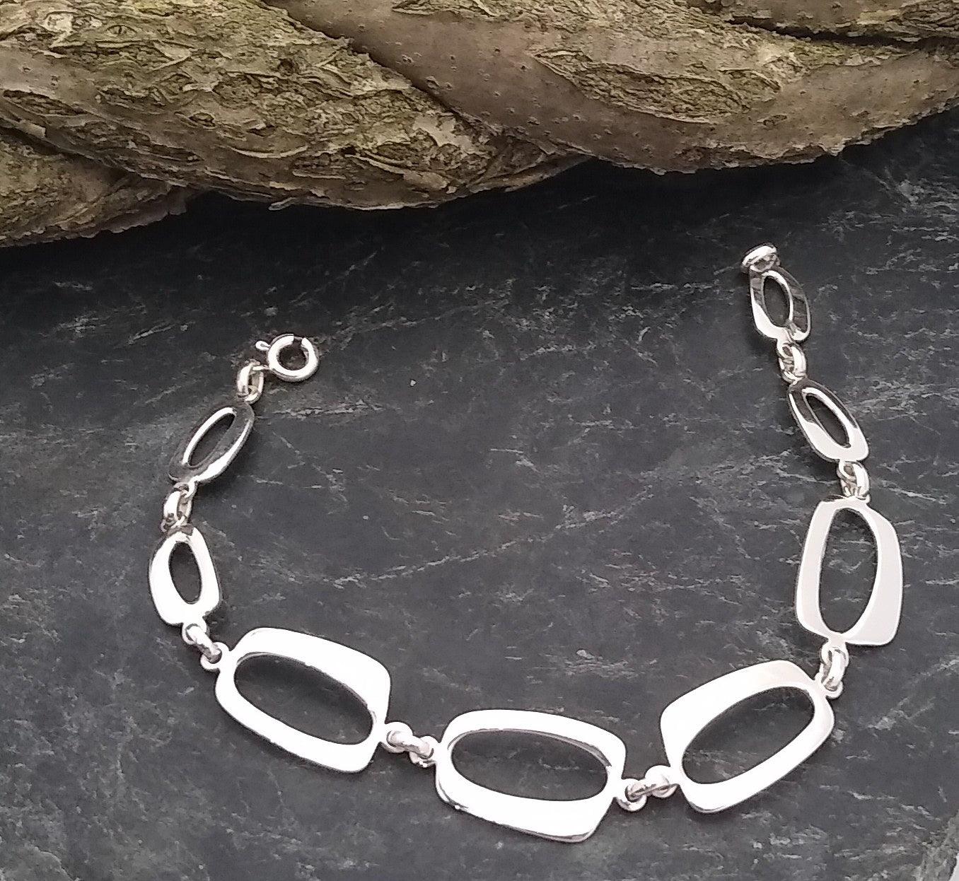 Sterling silver link bracelet with eight rectangular links each connected to the other by two sterling beads