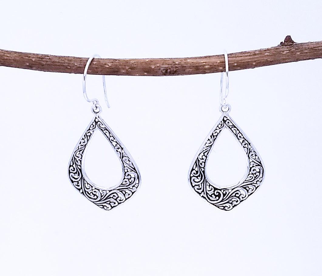 Sterling silver diamond-shaped cutout earrings with a swirl design in the metal, and a cutout middle.