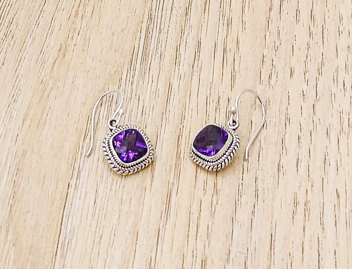 Sterling silver square-shaped earrings with a woven border on an Amethyst stone. Dangles from a French wire